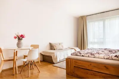 a bedroom with a bed and a table and a chair at Apartmán IRIS Poděbrady 2 in Poděbrady