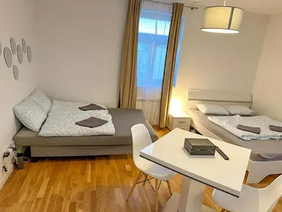 a small room with two beds and a table at Serene Apartment near Wenceslas Sq & Main Station in Prague