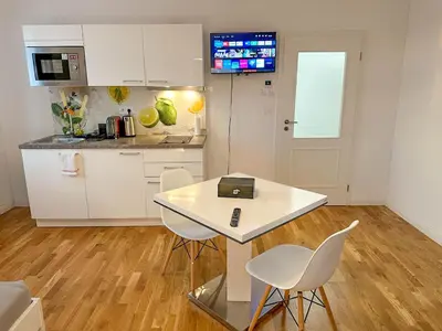 a kitchen with a table and two chairs and a counter at Serene Apartment near Wenceslas Sq & Main Station in Prague