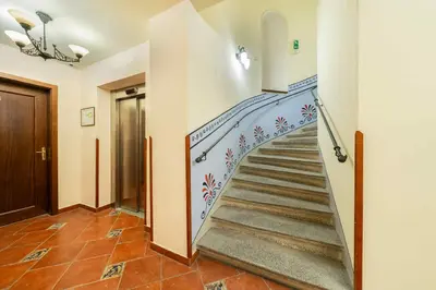 a staircase in a house with a painting on the wall at HOMELYI 28m2 Central studio with ELEVATOR and SELF CHECK-IN in Prague