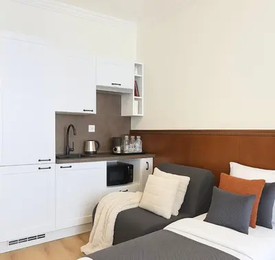 a living room with a couch and a kitchen at HOMELYI 28m2 Central studio with ELEVATOR and SELF CHECK-IN in Prague