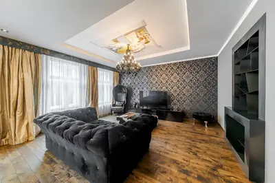 a living room with a black couch and a tv at 2 BR Designer Apartment in Old Town in Prague