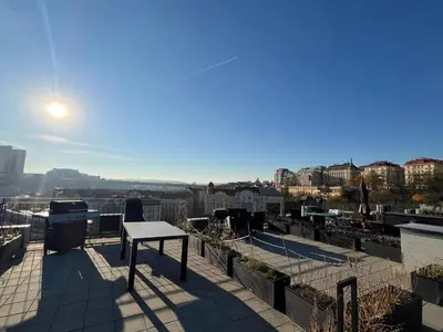a table on a balcony with a view of a city at GeraStay Perucka in Prague