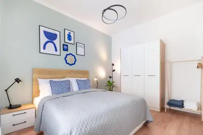 a white bedroom with a bed with blue pillows at Residence I at Havel's Market in Prague
