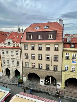 a building with a red roof next to other buildings at Residence I at Havel's Market in Prague