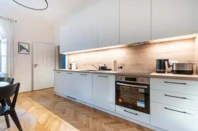 a kitchen with white cabinets and a stove top oven at Residence I at Havel's Market in Prague