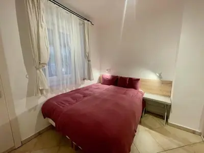 a bedroom with a large red bed and a window at Jakub's home in Prague