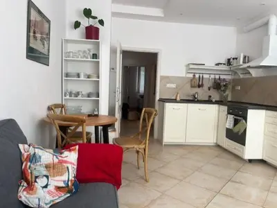 a living room with a table and a kitchen at Jakub's home in Prague