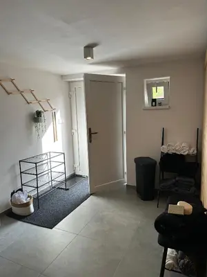 a living room with a door and a room with a rug at Chata Mšené-lázně - Vrbice in Loucká