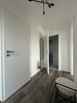 an empty living room with white walls and wooden floors at Chata Mšené-lázně - Vrbice in Loucká