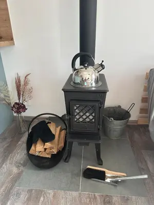 a black stove with a tea kettle on top at Chata Mšené-lázně - Vrbice in Loucká
