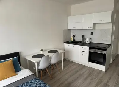 a small kitchen with a table and chairs and a bed at NEW beautiful apartment 15 minutes from the city center in Prague