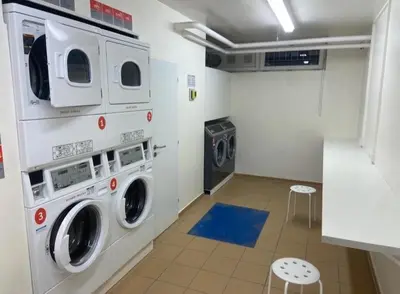 a laundry room with three washer and dryer machines at NEW beautiful apartment 15 minutes from the city center in Prague