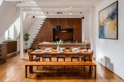 a dining room with a table and a kitchen at Prague Days - Family Two-Bedroom Apartment with, AC, and sound system in Vinohrady in Prague