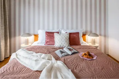 a bed with a plate of food and books on it at Prague Days - Family Two-Bedroom Apartment with, AC, and sound system in Vinohrady in Prague