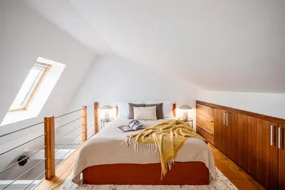 a bedroom with a large bed with wooden cabinets at Prague Days - Family Two-Bedroom Apartment with, AC, and sound system in Vinohrady in Prague