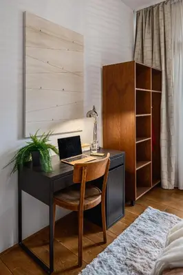 a desk with a laptop on it in a bedroom at Prague Days - Family Two-Bedroom Apartment with, AC, and sound system in Vinohrady in Prague