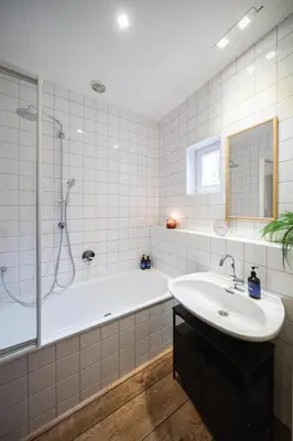 a white bathroom with a tub and a sink at Prague Days - Family Two-Bedroom Apartment with, AC, and sound system in Vinohrady in Prague
