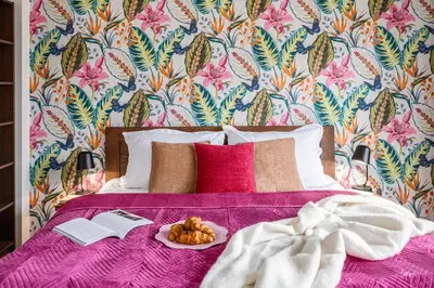 a bed with a purple blanket and a plate of food on it at Prague Days - Family Two-Bedroom Apartment with, AC, and sound system in Vinohrady in Prague