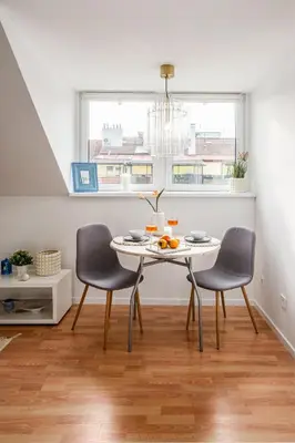 a dining room with a table and two chairs at Prague Days - One-Bedroom Apartment with Sauna, AC and Workspace in Žižkov in Prague