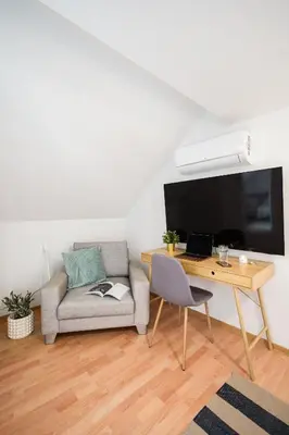 a living room with a couch and a desk at Prague Days - One-Bedroom Apartment with Sauna, AC and Workspace in Žižkov in Prague