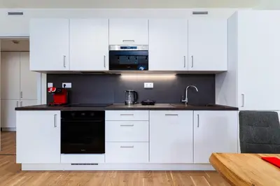 a kitchen with white cabinets and a sink and a microwave at Timeless Elegance Suite in Prague