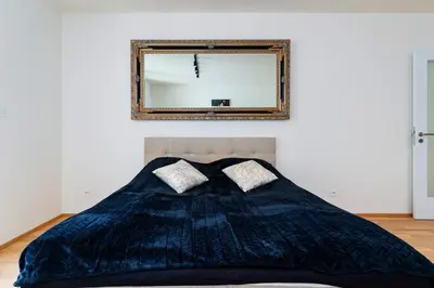 a bedroom with a bed with a mirror on the wall at Timeless Elegance Suite in Prague