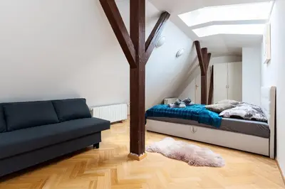 a bedroom with a bed and a couch at Royal Skyline Penthouse in Prague