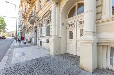 a building on a street with people walking down the street at Newly renovated flat with a loft in Prague