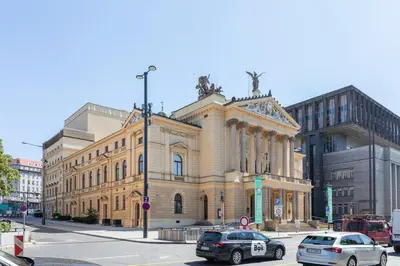 a large building with cars parked in front of it at Newly renovated flat with a loft in Prague