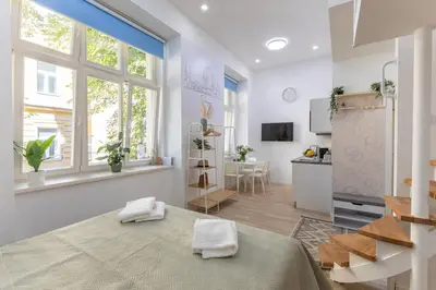 a kitchen and living room with white walls and windows at Newly renovated flat with a loft in Prague
