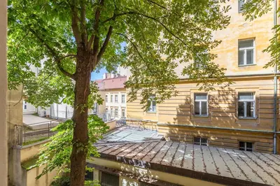 a building with a tree in front of it at Newly renovated flat with a loft in Prague