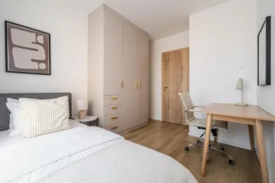 a bedroom with white cabinets and a red bed at Blueground Prague 7 furnished close to offices PRG-12 in Prague