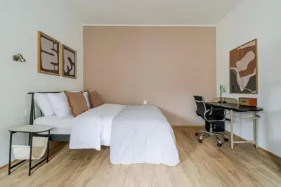 a bedroom with a white bed and a desk at Blueground Anděl view nr Vltava River PRG-80 in Prague