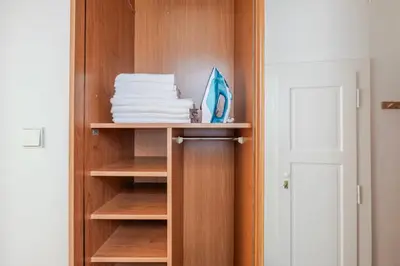 a closet with wooden shelves and a stack of towels at Blueground Anděl view nr Vltava River PRG-80 in Prague
