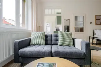 a living room with a blue couch and a table at Blueground Anděl view nr Vltava River PRG-80 in Prague