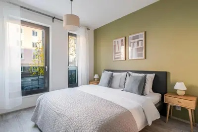 a bedroom with a large bed and a window at Blueground Žižkov balcony nr Vítkov Hill PRG-82 in Prague