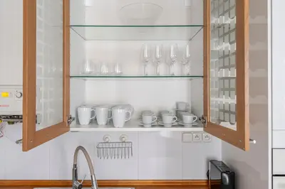 a kitchen with cups and glasses in a cabinet at Blueground Vršovice view nr Havlíčkovy sady PRG-81 in Prague