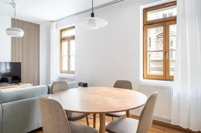 a living room with a wooden table and chairs at Blueground Vršovice view nr Havlíčkovy sady PRG-81 in Prague