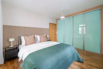 a bedroom with a large bed and a large window at Blueground Vršovice view nr Havlíčkovy sady PRG-81 in Prague