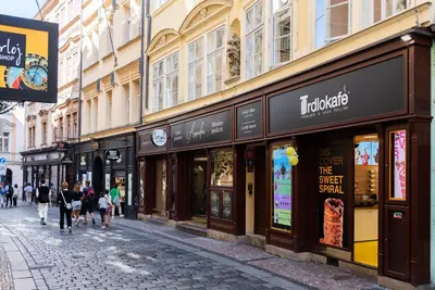 people walking down a street in front of stores at 7 Tales Apartments by Adrez in Prague