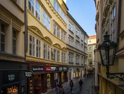 a group of people walking down a street with buildings at 7 Tales Apartments by Adrez in Prague