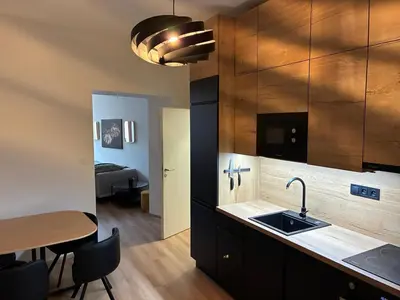 a kitchen with a sink and a table and a room at Luxurious Studio Apartment Vyšehrad in Prague
