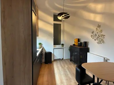 a living room with a table and a kitchen at Luxurious Studio Apartment Vyšehrad in Prague