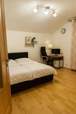 a bedroom with a bed and a desk with a computer at Dream House Prague East in Kamenice