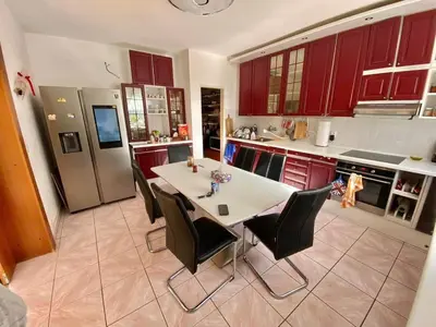 a kitchen with red cabinets and a table and chairs at Dream House Prague East in Kamenice
