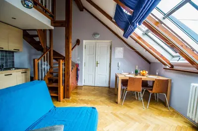 a kitchen and dining room with a blue couch and a table at Ruterra Red Roofs View With Garage in Prague