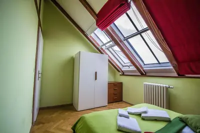 a room with a bed and a white refrigerator at Ruterra Red Roofs View With Garage in Prague