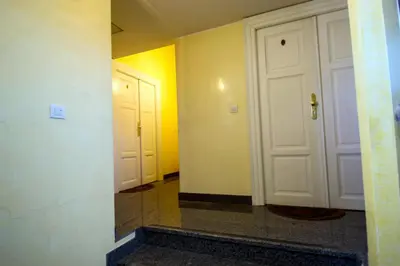 a hallway with two white doors and yellow walls at Ruterra Red Roofs View With Garage in Prague