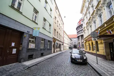 a black car parked on a cobblestone street at Ruterra Red Roofs View With Garage in Prague